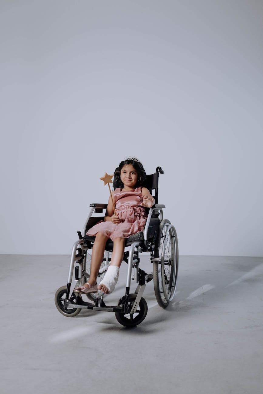 a girl sitting on a wheelchair holding a magic wand
